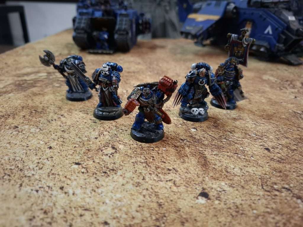 Al centro Marneus calgar, acompañado de de personajes de los ultramarines