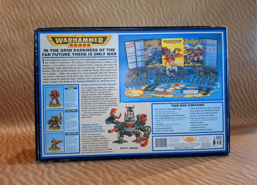 Parte de atrás de la caja de segunda edición de Warhammer 40k, aparece el contenido de la caja, 20 marines, 20 orkos, 40 gretchins y  todo lo necesario para jugar