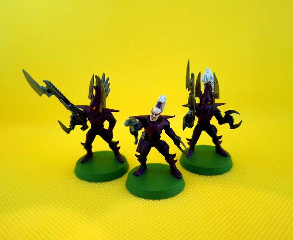 Tres miniaturas diferentes de Kabalite warriors, al centro un Kabalite warrior sin casco